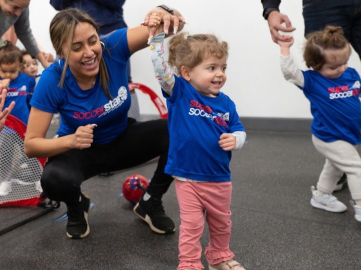 A coach plays with toddlers